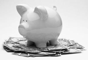 Pink Piggy Bank On Top Of A Pile Of One Dollar Bills